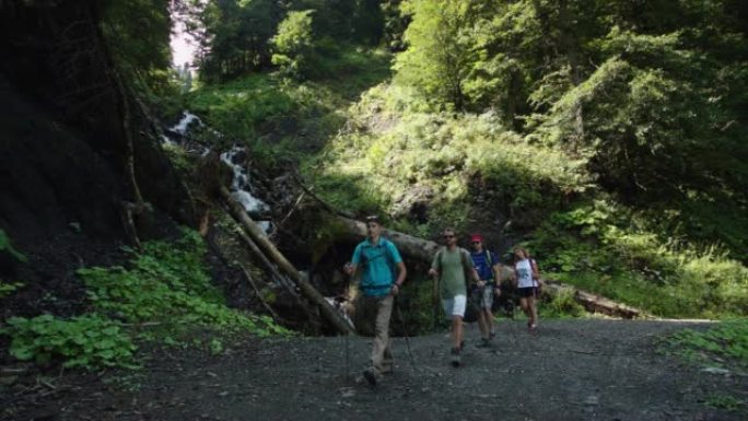 四名游客正驶过从高处坠落的溪流，河道上到处都是倒下的树木和大石头。一群运动员的快速运动