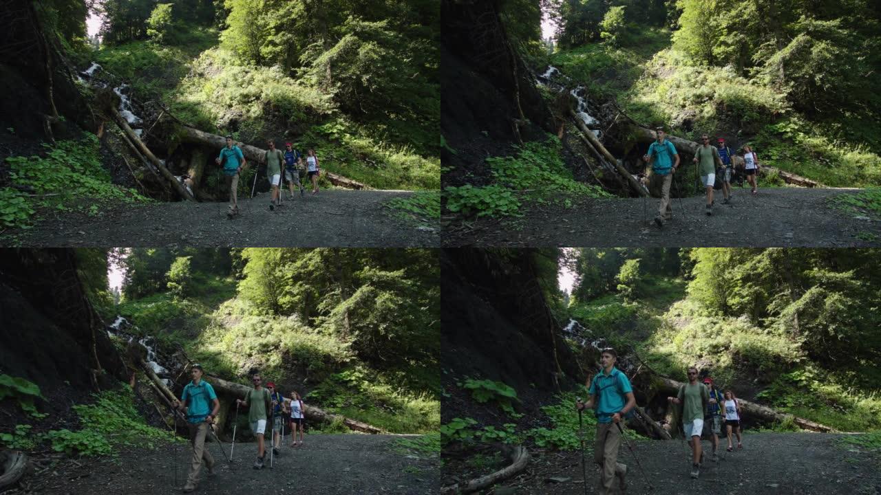 四名游客正驶过从高处坠落的溪流，河道上到处都是倒下的树木和大石头。一群运动员的快速运动