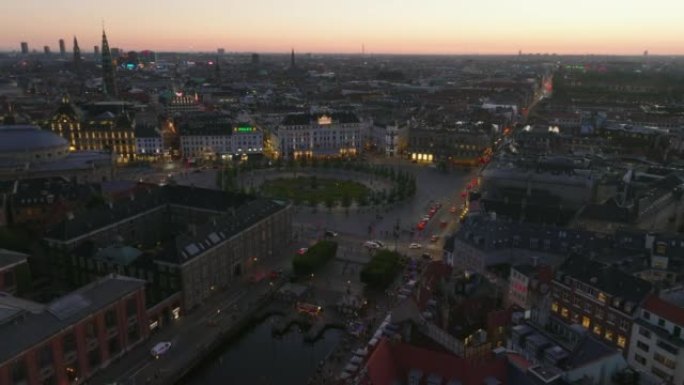 黄昏时城市景观的电影镜头。晚上，Kongen Nytrov广场的鸟瞰图和城市entre的交通。丹麦哥