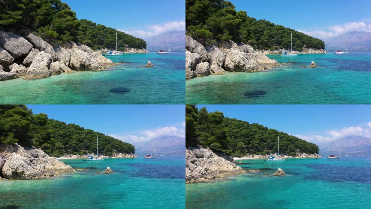 游艇、帆船和双体船停泊在清澈蓝色的地中海上异国情调的山岛附近的海湾。停泊在海岸附近的白色帆船。停泊在