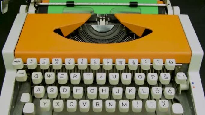 打字机时尚橙色。老式机械打字机。白色键盘绿纸。