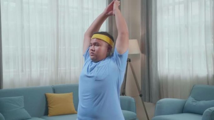 胖胖的亚洲男人在战士里做瑜伽我在家里的垫子上摆姿势