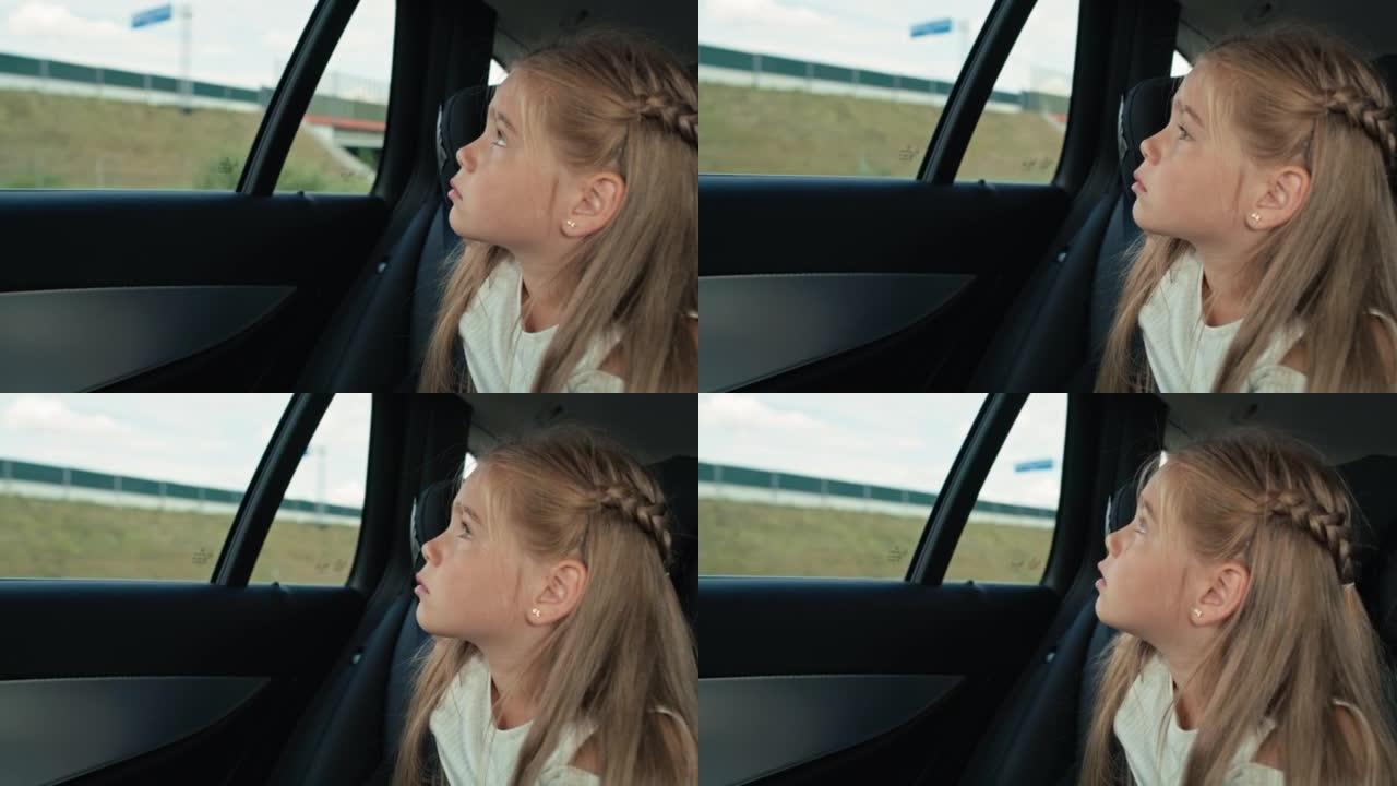 8岁的高加索女孩在汽车旅行时看着车窗外。用8k的红氦相机拍摄。