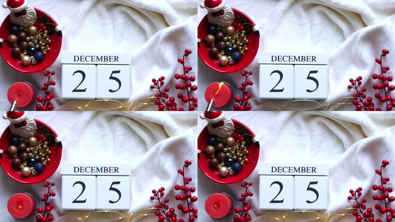 日历，带有12月25日日期和红色蜡烛，红色浆果，白色针织面料上的圣诞节装饰。圣诞节和新年快乐的概念。
