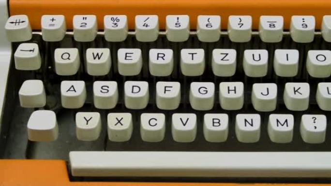 打字机键盘特写。相机旅行多莉从左到右。漂亮时尚的橙色复古机械。