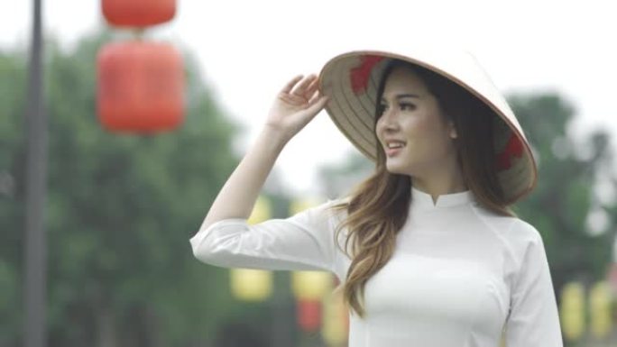 越南女人穿着传统服装和亚洲风格的圆锥形帽子走在街上