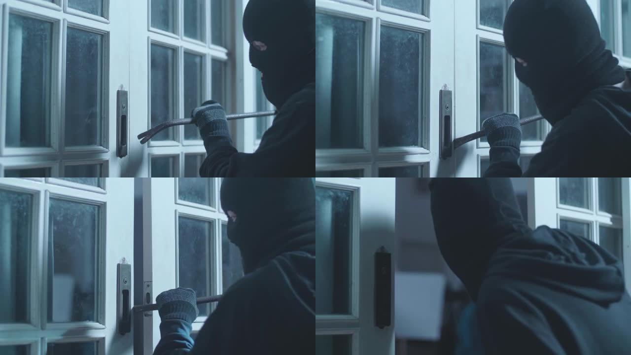 小偷拿着手电筒，用撬棍打开门，然后进入某人的房子