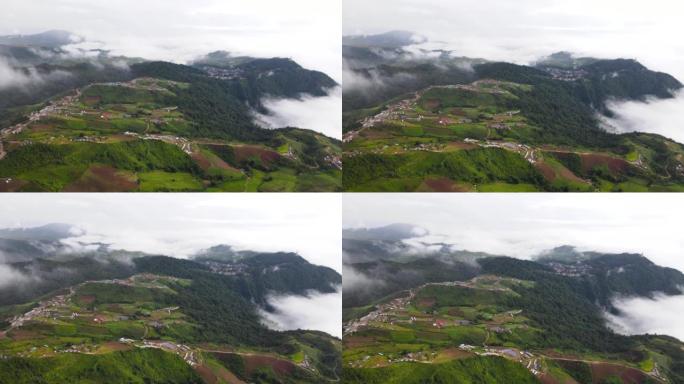 在带有雾的局部山脉上飞越村庄