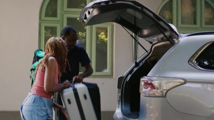 男女朋友把行李和手推车放在汽车后备箱里
