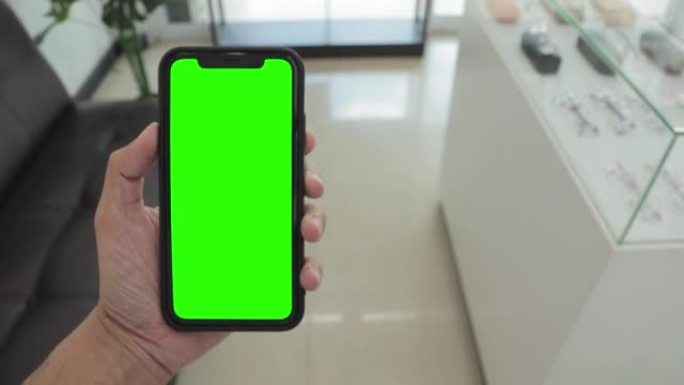 手持智能手机，手持iPhone 11，绿屏智能手机