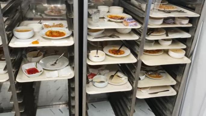 大学食堂厨房内的架子上堆放着旧盘子和碗
