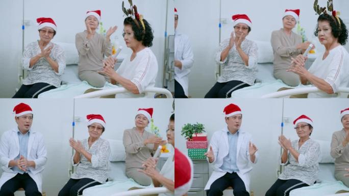 一群戴着圣诞帽的微笑的资深朋友正在唱圣诞歌曲，并与迷人的亚洲医生男性一起拍手。老年男女在养老院的圣诞