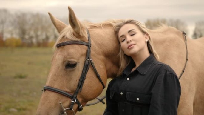 Stylish woman stroking a beautiful horse outdoors