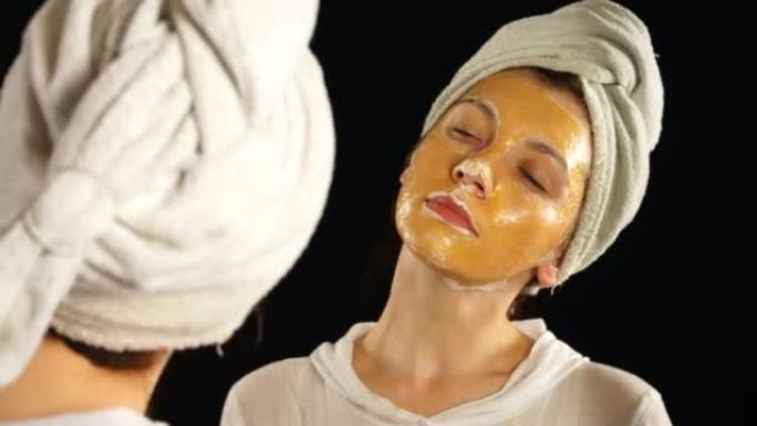 30-35岁的女人涂了化妆品面膜。模型照镜子。
