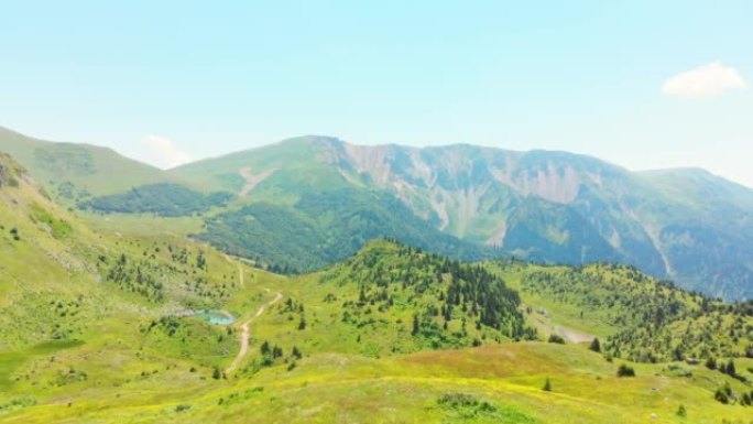 在偏远高加索地区的风景秀丽的绿色山谷中，空中飞越背着背包的单人女徒步旅行者