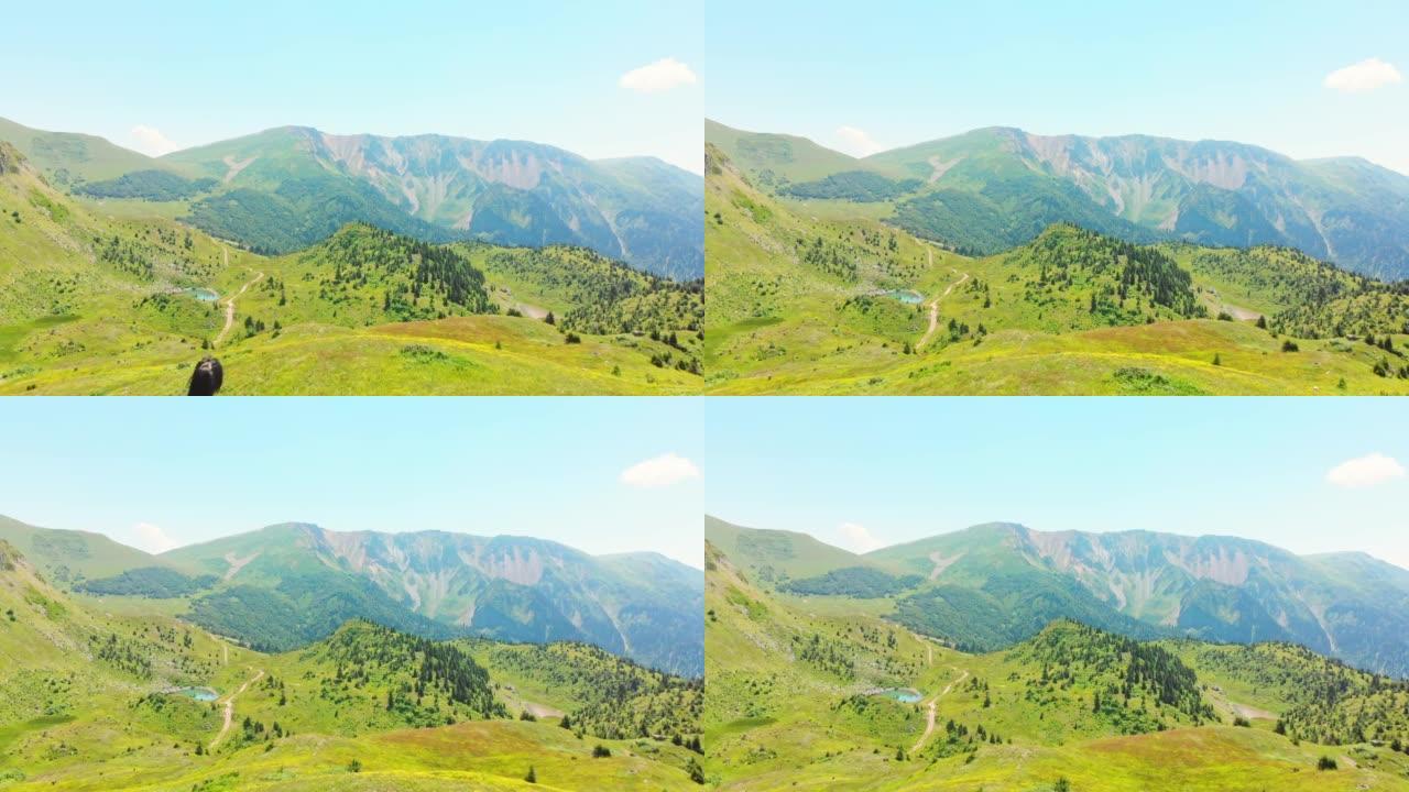 在偏远高加索地区的风景秀丽的绿色山谷中，空中飞越背着背包的单人女徒步旅行者