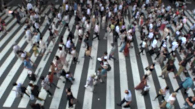 日本大阪: 在斑马线上行走的人群。