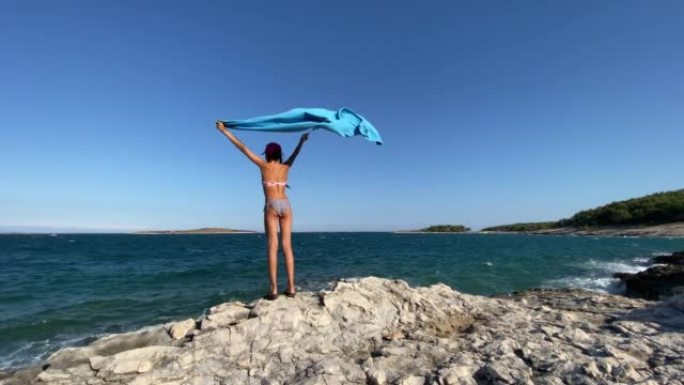 Girl holding a towel and looking at horizon on the