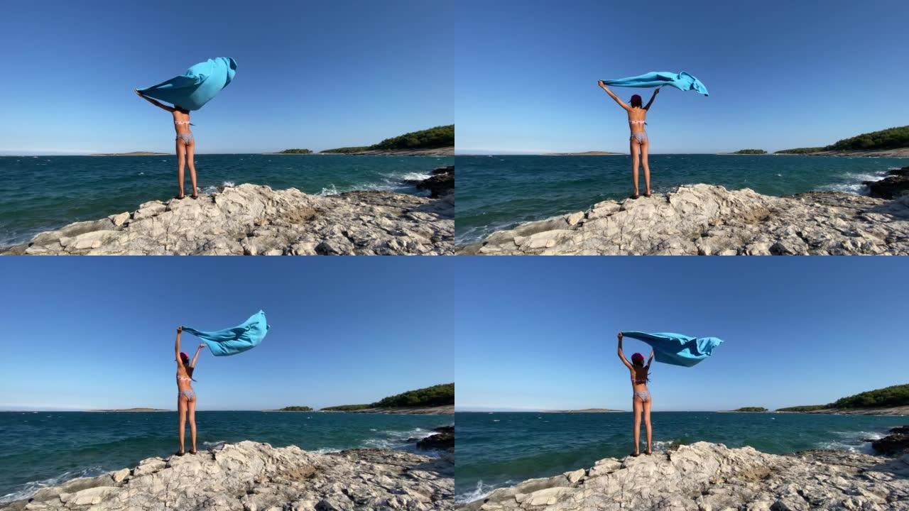 Girl holding a towel and looking at horizon on the