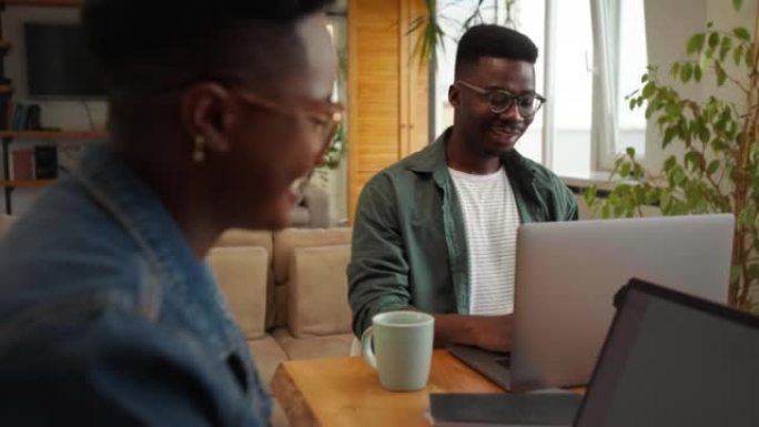 Two black workers in the home office, using techno