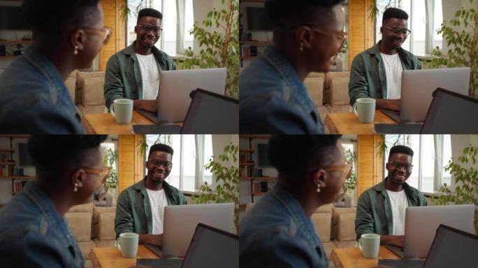 Two black workers in the home office, using techno