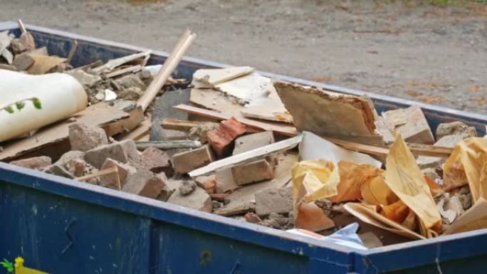 大型金属垃圾箱容器，里面装有危险建筑材料垃圾废物