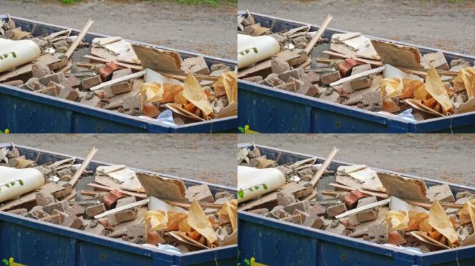 大型金属垃圾箱容器，里面装有危险建筑材料垃圾废物