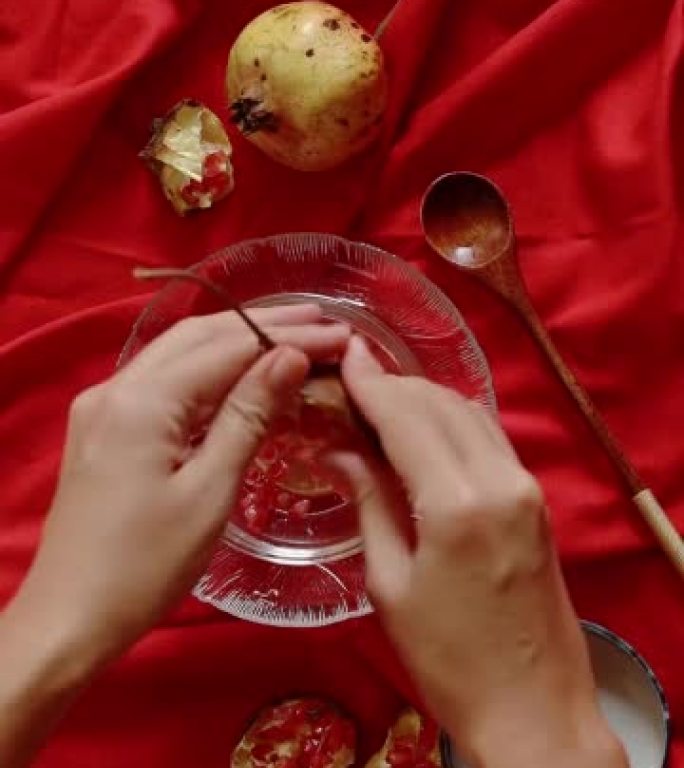 在红色背景下播种石榴果以制作果汁的垂直视频