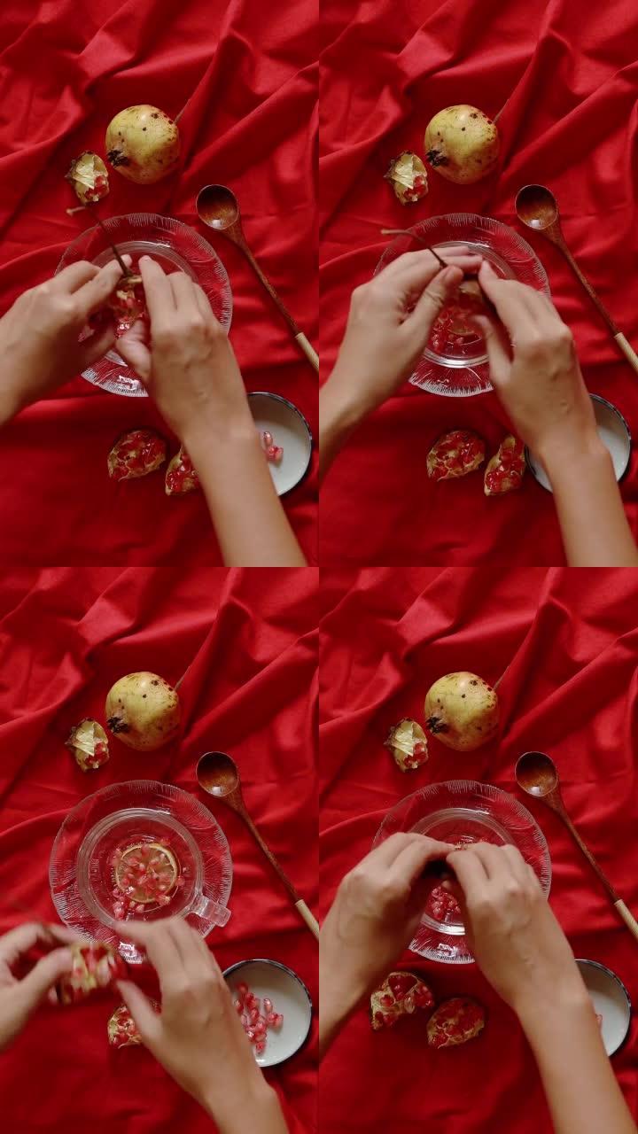 在红色背景下播种石榴果以制作果汁的垂直视频