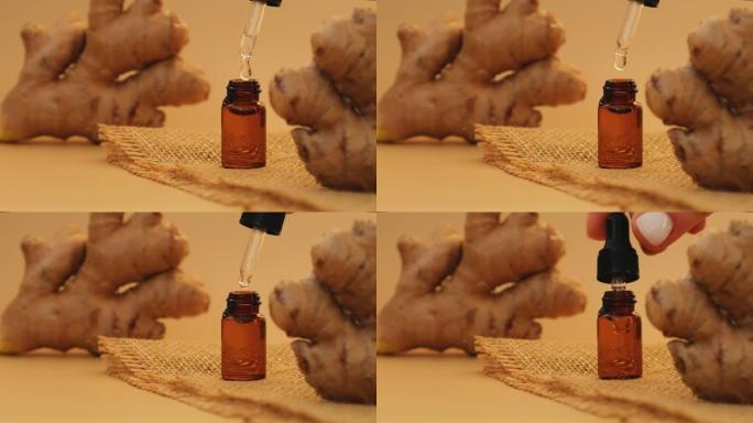 玻璃移液器的基本的姜油滴，姜根在米色背景。芳香疗法、水疗和草药成分。姜