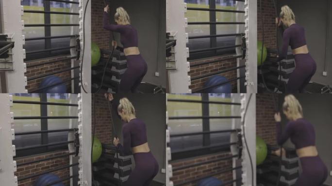 女人在健身房的滑轮上拉橡皮筋，恢复过程