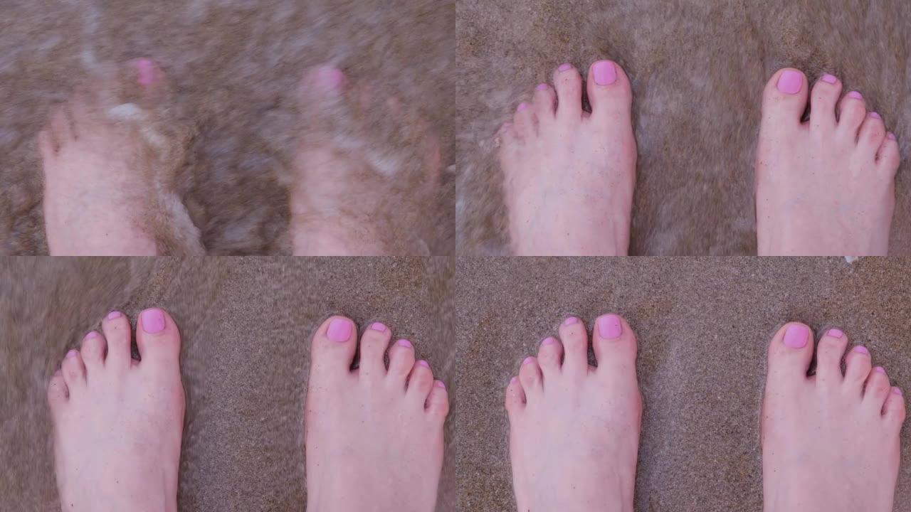 粉红色指甲的女人的腿。海浪和沙卷。从上方观看