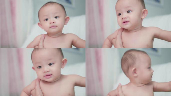 真实的肖像照片脸可爱的亚洲新生婴儿在卧室。当母亲在附近照顾时，家庭时光快乐。天真的小新婴儿可爱。父母