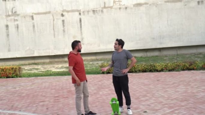 Two men talking on skateboards in the park