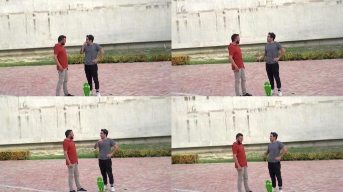 Two men talking on skateboards in the park