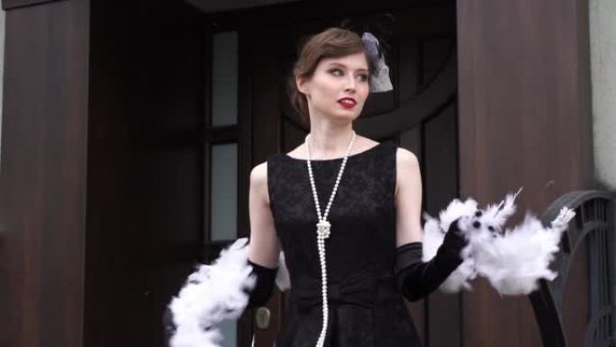 缓慢的运动。一个女人在镜头前跑下楼梯。一个年轻的女孩，穿着XX世纪20-30年代的黑色连衣裙，带着一