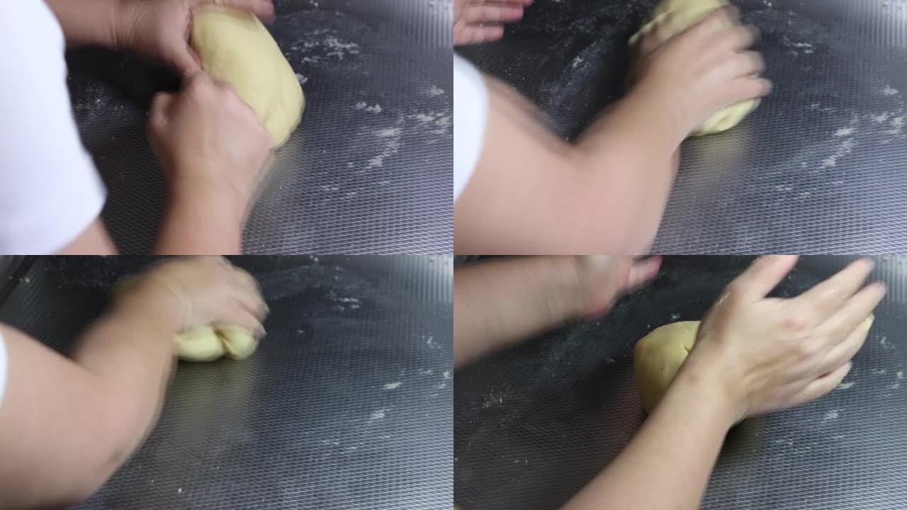 制作低碳水化合物的酮百吉饼，女性的手在金属表面上揉面团