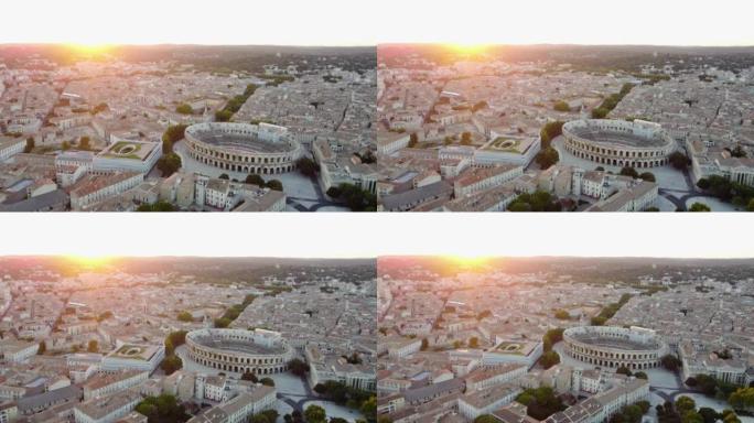 尼姆竞技场的空中回撤视图，罗马圆形剧场，美丽的金色日落天空