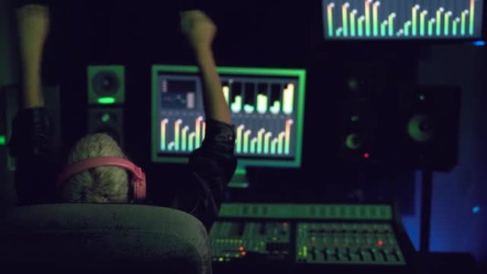 在音乐录音棚工作的年轻女性 -- 在制作室内混音的女性音频工程师
