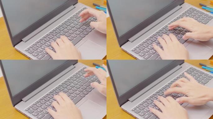 女商人用电脑笔记本电脑在键盘上打字的特写手。女人的手在家里的工作台上聊天或写文章。B滚动打字到计算机
