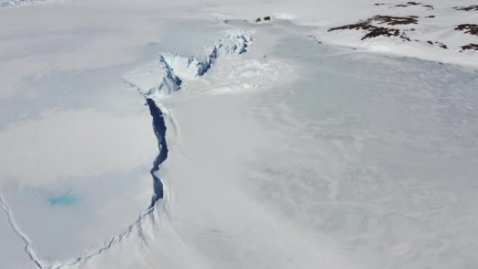 积雪覆盖的南极地表鸟瞰图飞行。