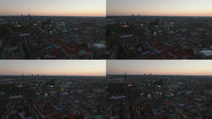 城市中心在黄昏的惊人电影镜头。飞过历史建筑的上空，与市政厅广场周围外墙的彩色霓虹灯形成对比。丹麦哥本
