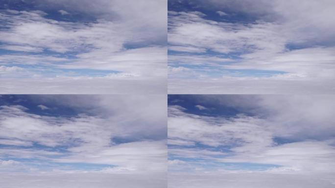 飞机窗户的鸟瞰图，它在白云之间飞来飞去，蓝天超过。