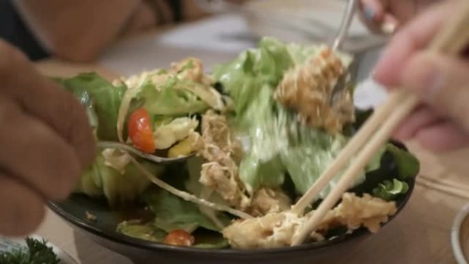 从一盘日本开胃菜中采摘带炸软壳蟹的沙拉
