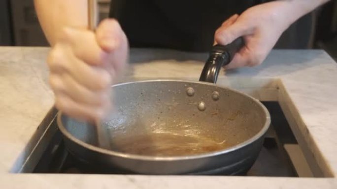 日本厨师在电锅中搅拌warabi mochi糕点面团。