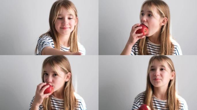 一个小女孩坐在厨房里吃苹果当早餐。美味的红苹果