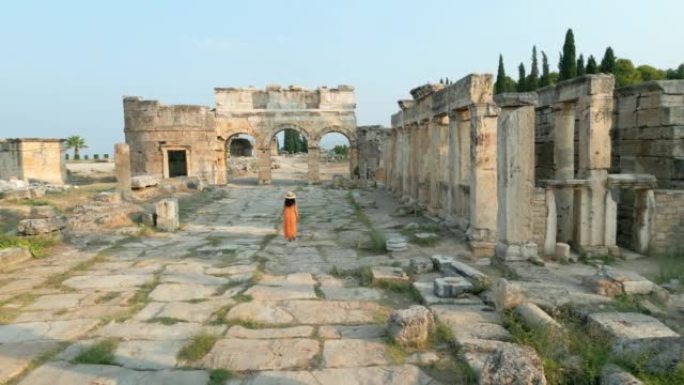 无人机拍摄的一名女游客正走向德尼兹利Pamukkale希拉波利斯古城遗址的Frontinus大门