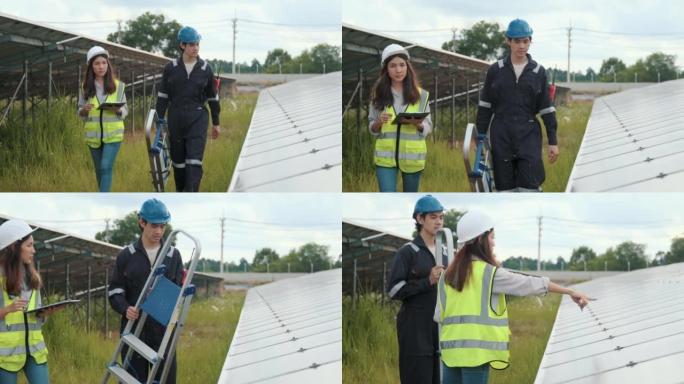 两名穿着制服和安全帽的工人在太阳能农场中检查太阳的运行和光伏太阳能电池板的清洁度。生态概念