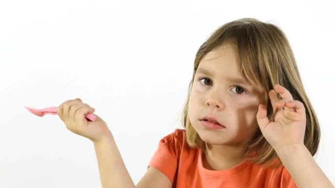 4-5岁的孩子，手里拿着塑料叉子的女孩。在白色背景的摄影棚里拍摄。