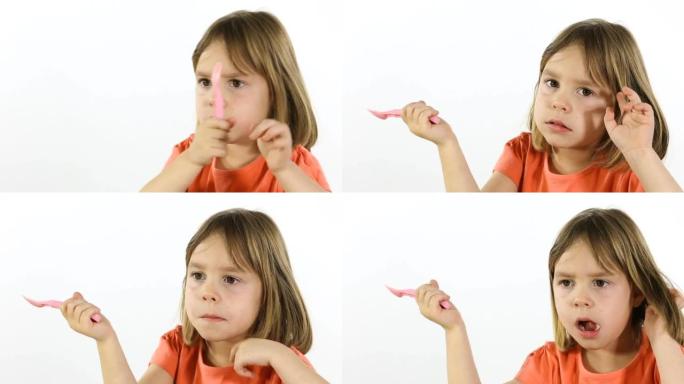 4-5岁的孩子，手里拿着塑料叉子的女孩。在白色背景的摄影棚里拍摄。